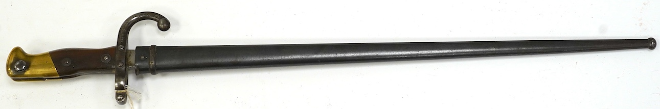 An 1875 French T-section bayonet in its steel scabbard for a Gras rifle, with engraving in French to the top of the blade. Condition - good